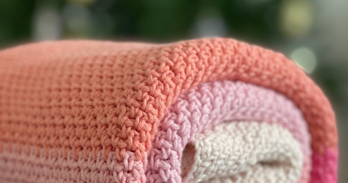 Folded handmade crocheted baby blanket with vibrant colors