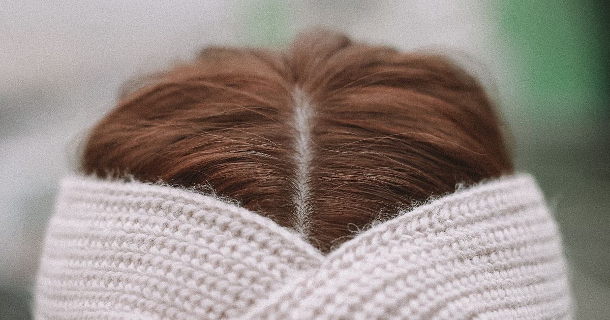 Woman wearing a knitted headband, close-up on a foggy day.