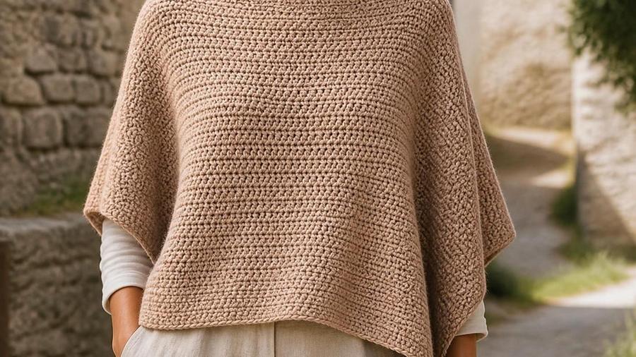 A woman wearing a simple beige crochet poncho outdoors on a stone pathway.
