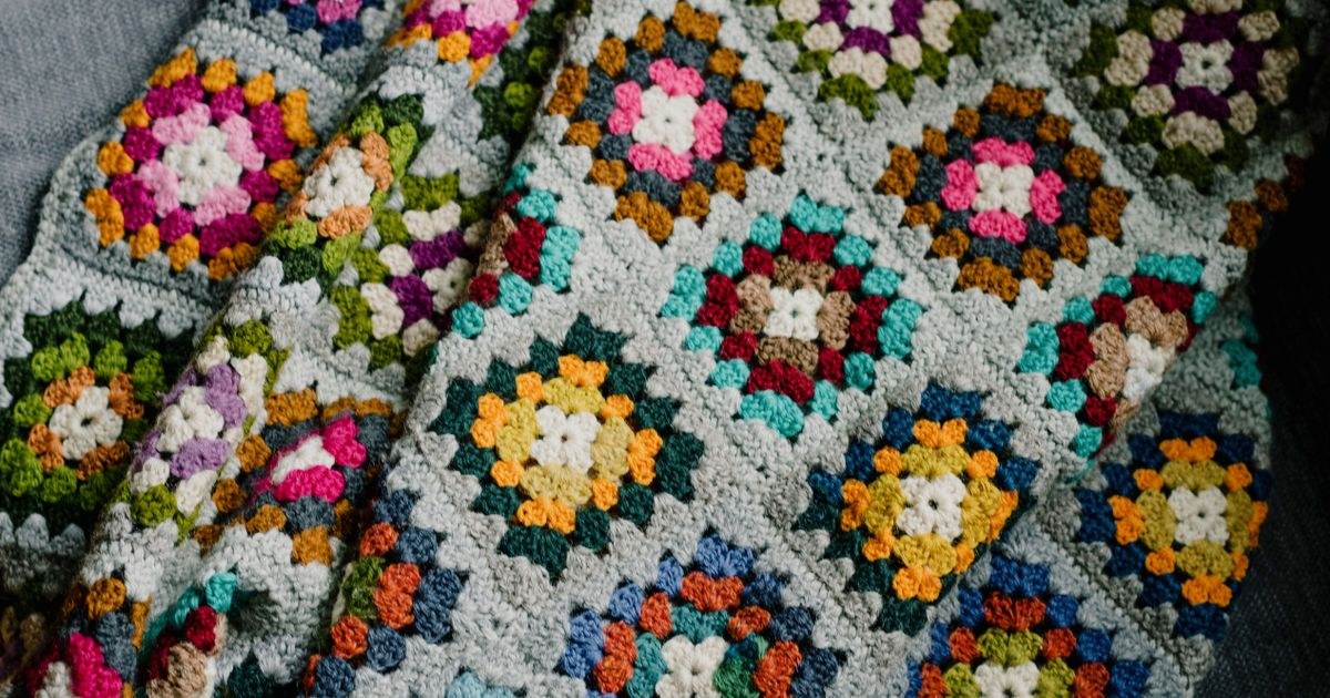 A vibrant handmade crochet blanket featuring geometric patterns in various colors.