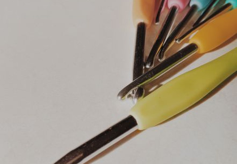 A set of colorful crochet hooks on a neutral surface
